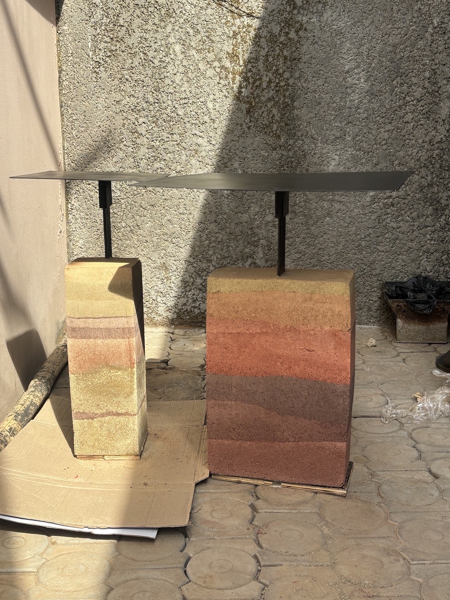 Rammed earth stools with layered pigment bands