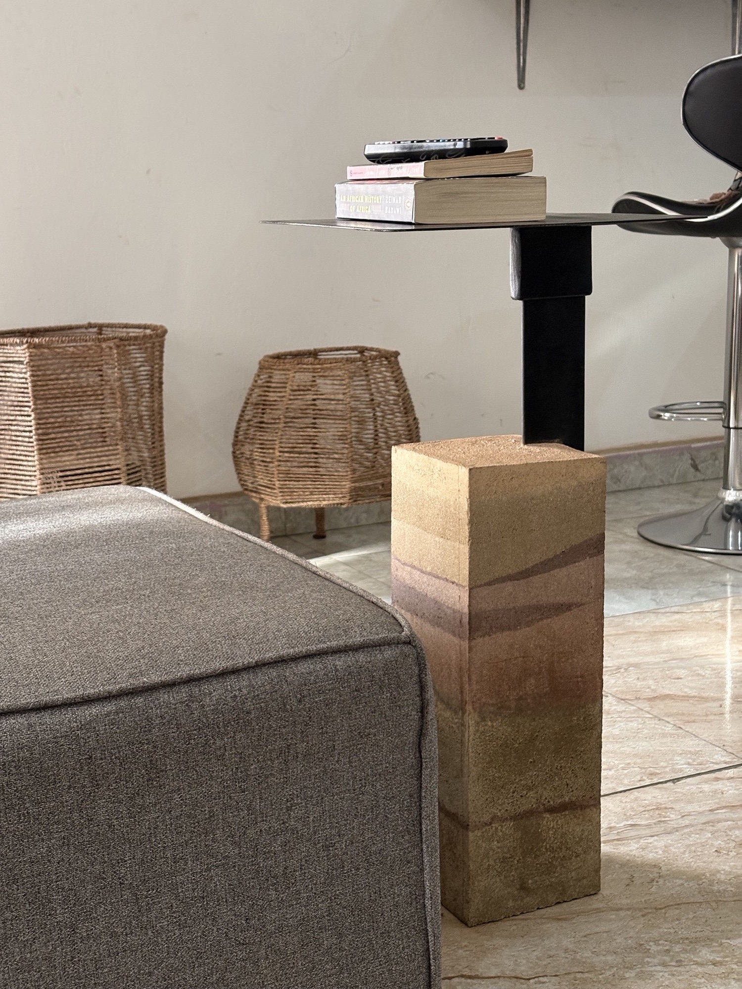 Rammed earth side table with layered pigments in a living room